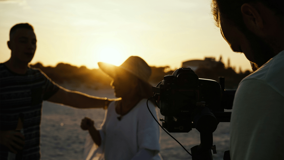  Three people at sunset filming their project which will use royalty free music for documentaries.