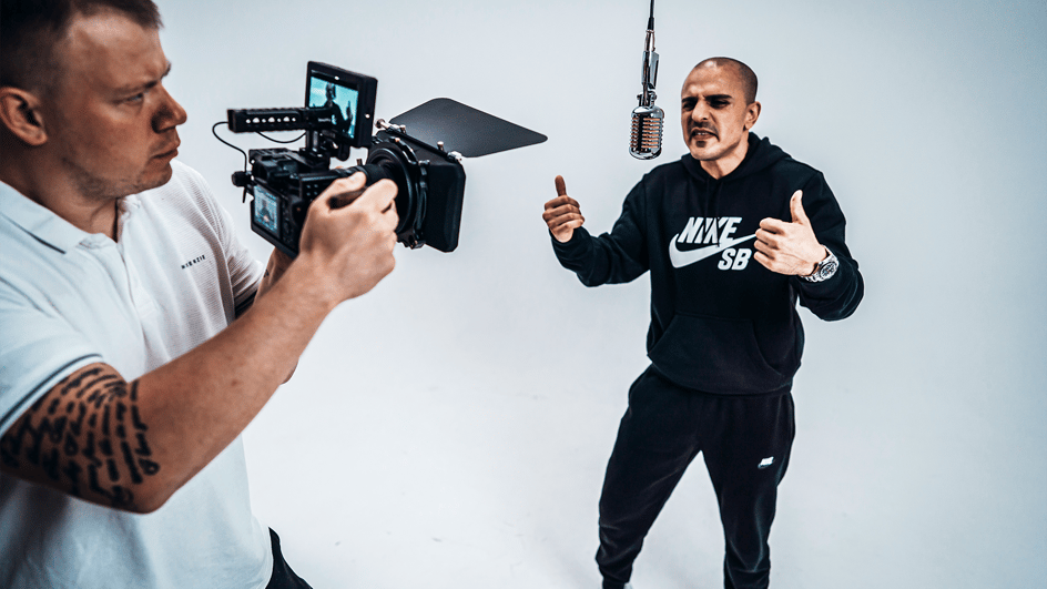  A videographer captures a man singing into a microphone, wondering, “How many views to go viral?”