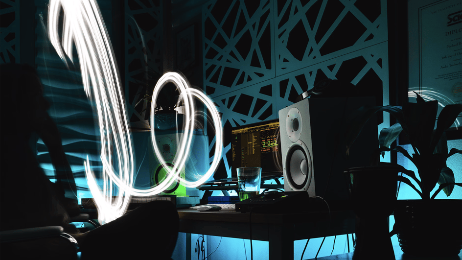  Person sitting at a desk listening to royalty free ai music, looking at a light image coming from a computer
