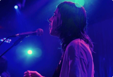 Soundstripe artist Vaultz performs on stage under blue lights, performing original music available for sync licensing.